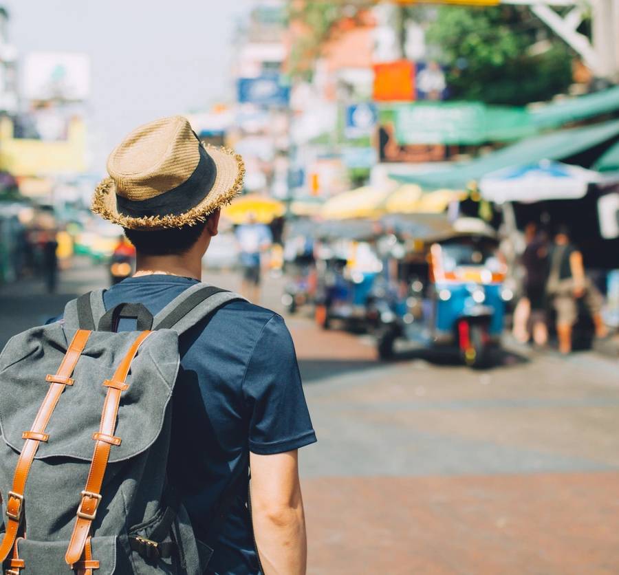 Young Asian traveling backpacker in Khaosan Road outdoor market in Bangkok, Thailand